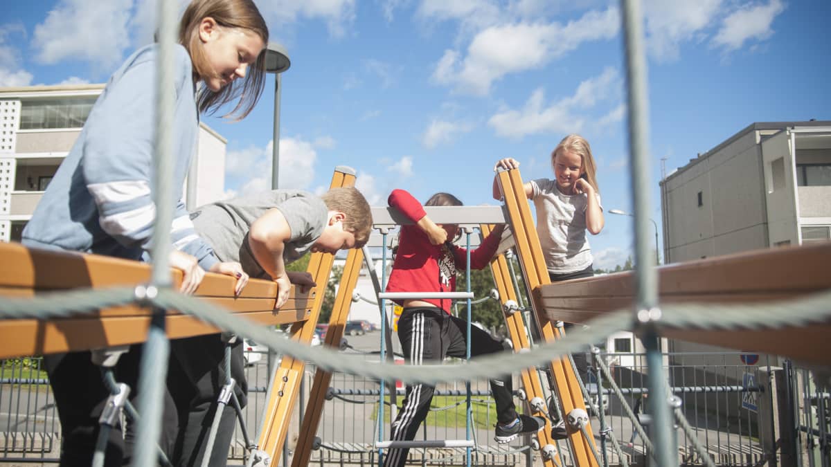 Lapset kiipeilevät välitunnilla.