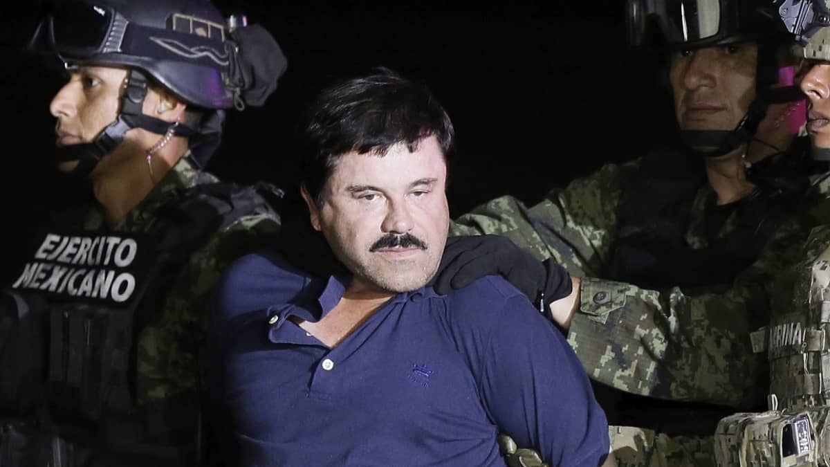 Huumekuningas El Chapo oliisin otteissa, Katsoo kohti kameraa. 