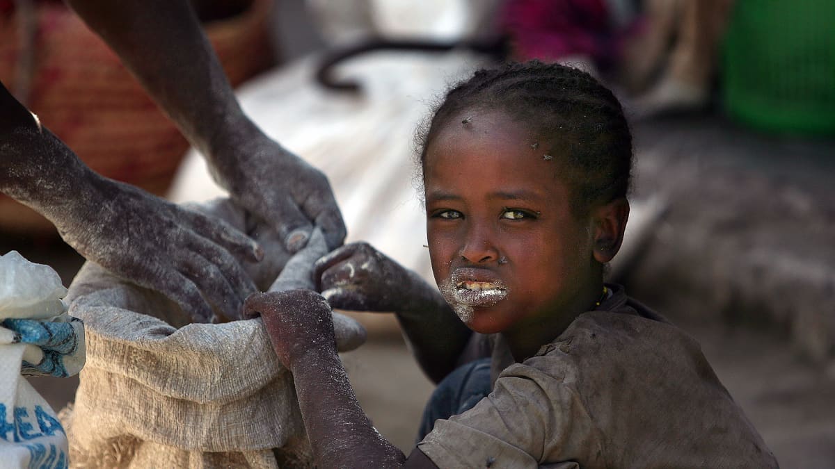 Etiopialainen tyttö syö suoraan maissisäkistä.