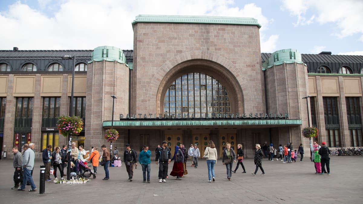 Ihmiset sytyttivät kynttilöitä ja toivat kukkia Helsingin Asema-aukiolle.