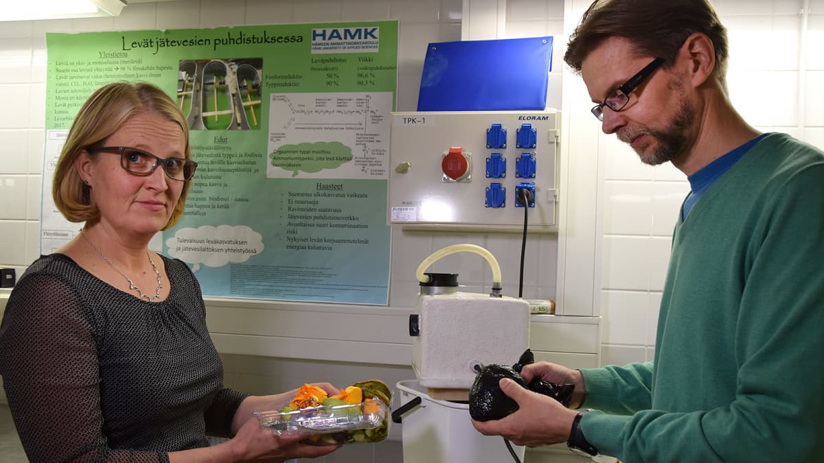 Nainen ja mies esittelevät biojätteenkäsittelylaitteistoa