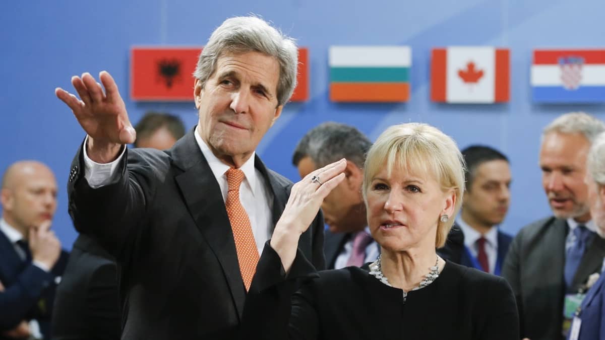 John Kerry ja Margot Wallström katsovat ohi kameran Kerryn käden osoittamaan suuntaan.