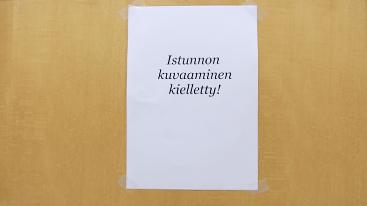 Kyltti istunnon kuvaamiskiellosta Oulun käräjäoikeuden istuntosalin ovessa 12.10.2016