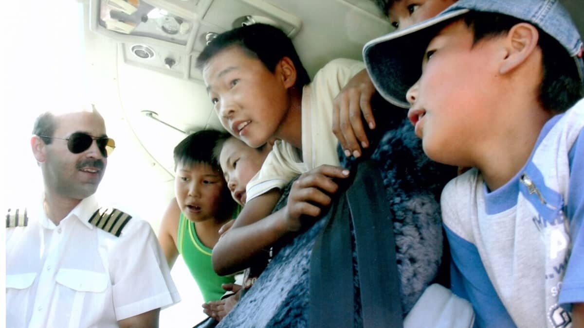 Avustuslentäjä Janne Ropponen Mongoliassa Etelä-Gobin Manlaissa esittelemässä konettaan lapsille lennon tauolla