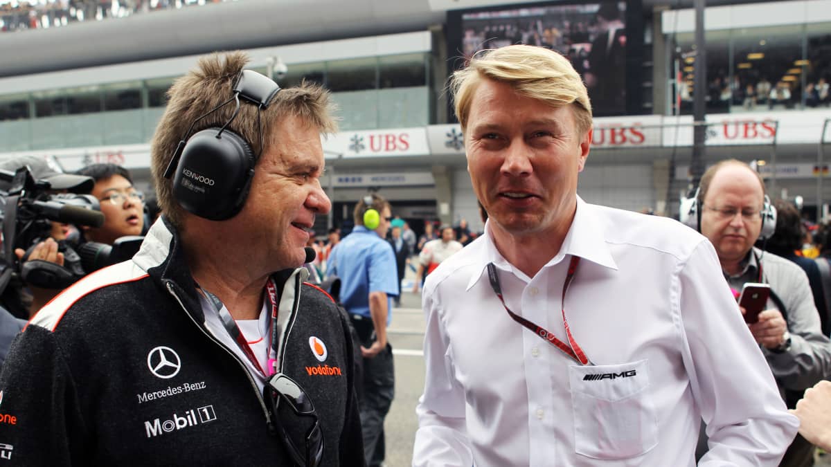 McLarenin lääkäri Aki Hintsa ja Mika Häkkinen hymyilevät F1-varikolla vuonna 2012.