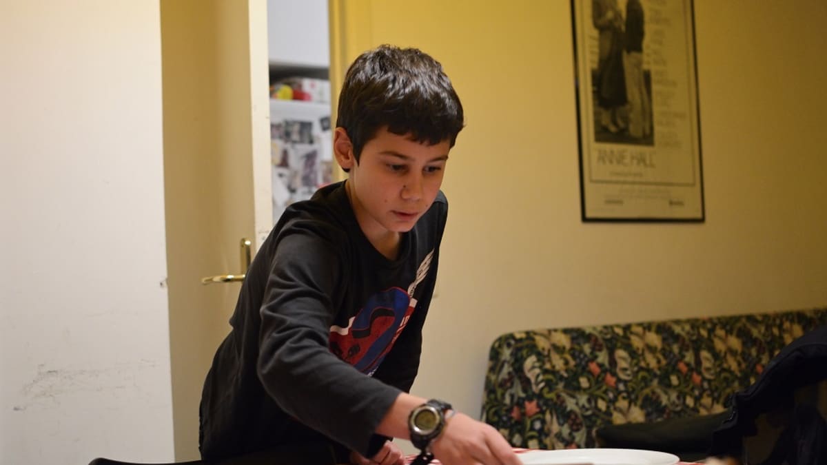 11-vuotias Francesco kattaa lautasia pöydälle.