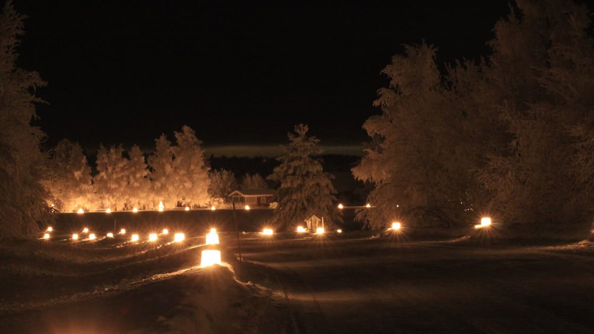 Luminen ja pimeä maisema, jossa jäälyhtyjä tien varrella 