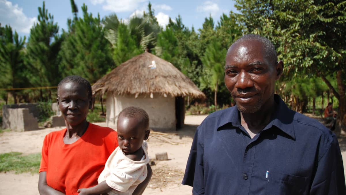 Ugandalainen Maxwell Oninje vaimonsa ja lapsensa kanssa.