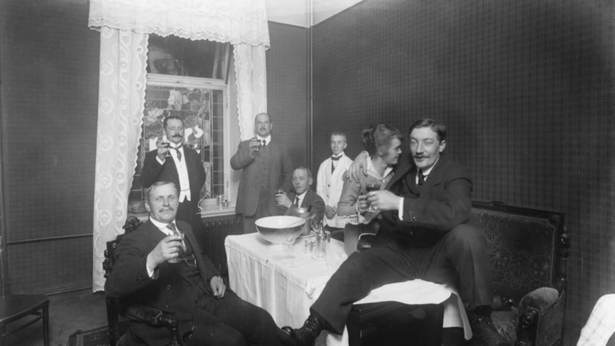 Naiset ja miehet juovat kabinetissa alkoholia