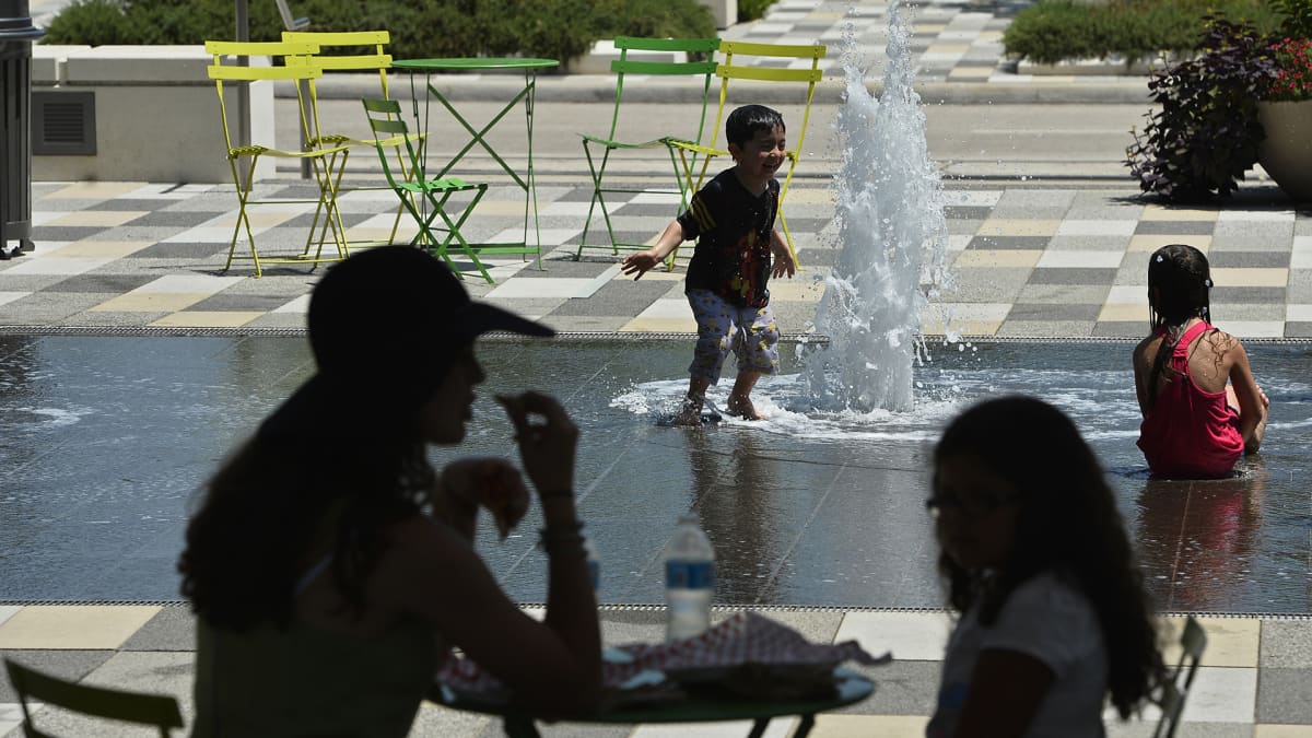 Lapset leikkivät kuumana kesäpäivänä Dallasissa suihkulähteessä.