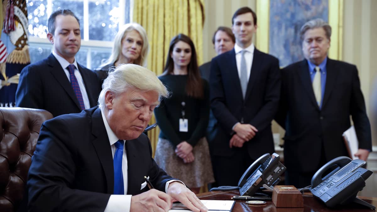 Donald Trump kuvattuna taustajoukkoineen Valkoisessa talossa 24. tammikuuta 2017.