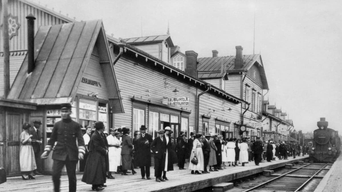 Riihimäen rautatieasema. Asemalaituri, jossa matkustajat odottavat juuri saapuvaa junaa.