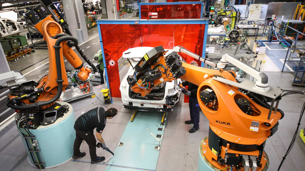 Robotit työskentelevät ihmisten kanssa saksalaisessa autotehtaassa.