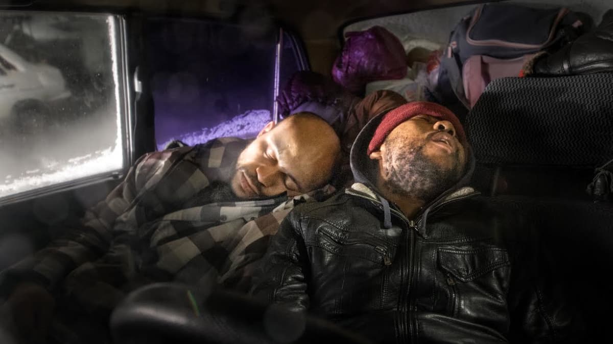Kaksi miestä nukkuu autossa