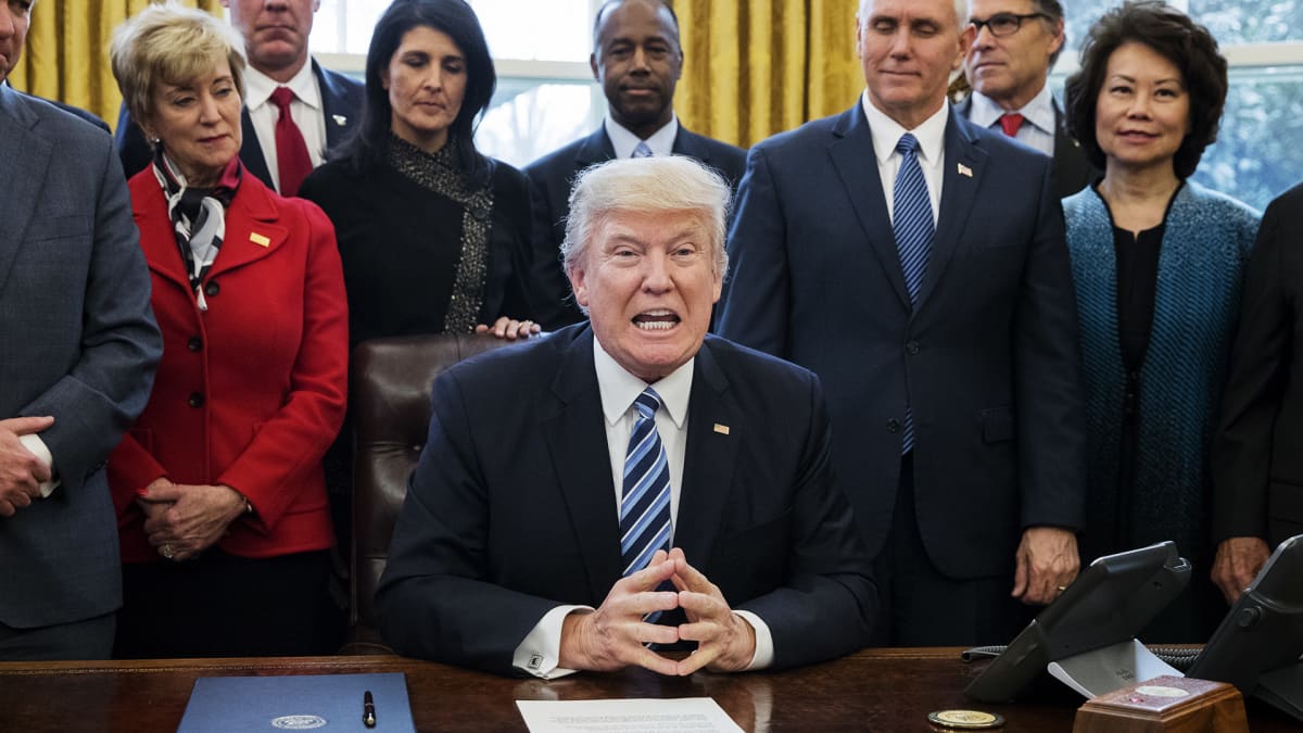 Donald Trump lähipiirinsä ympäröimänä Valkoisessa talossa maanantaina 13. maaliskuuta.
