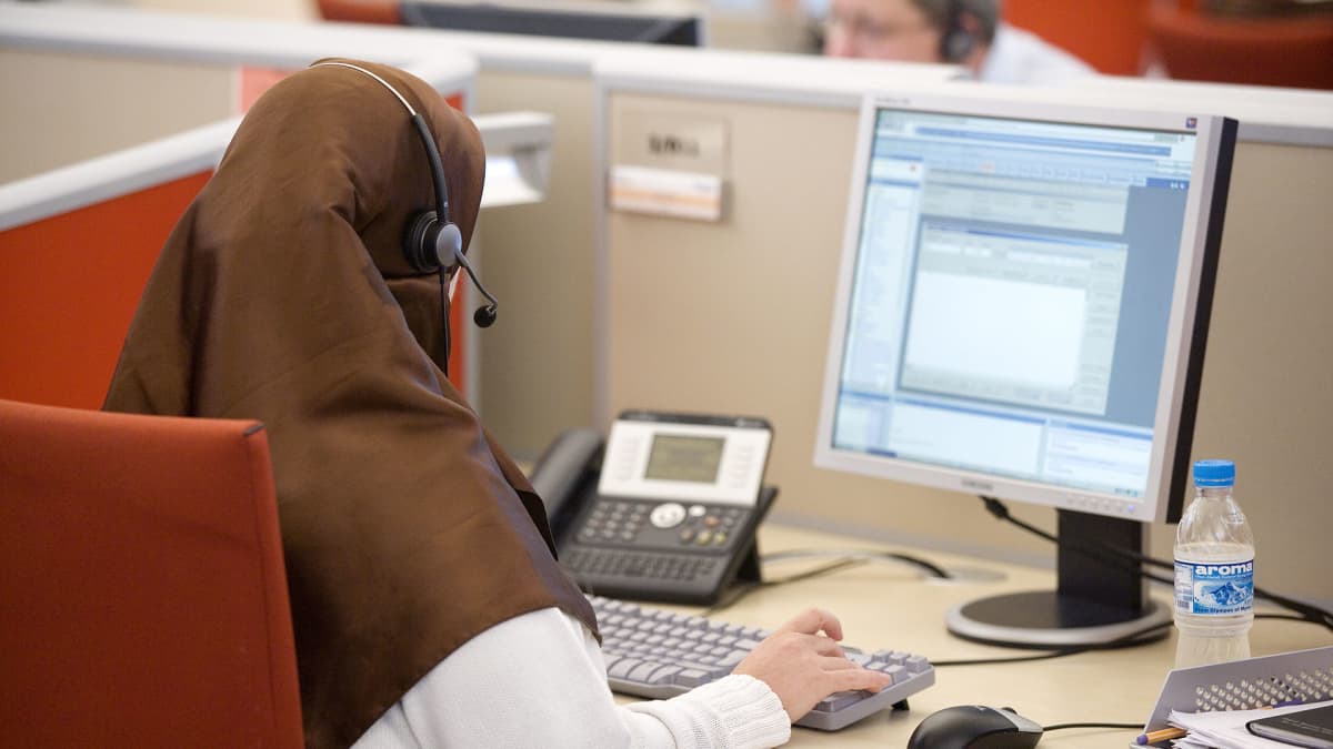 Muslimi nainen työskentelee puhelinkeskuksessa.