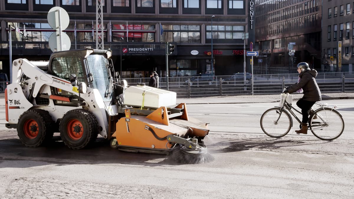 Lakaisukone puhdistaa jalkakäytävää hiekoitushiekasta ja katupölystä Arkadiankadulla Helsingissä.