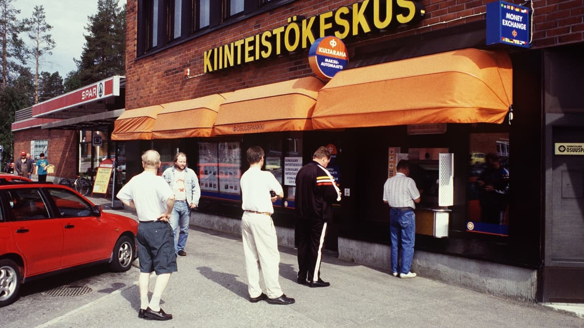 Ihmisiä jonottamassa pankkiautomaatille.