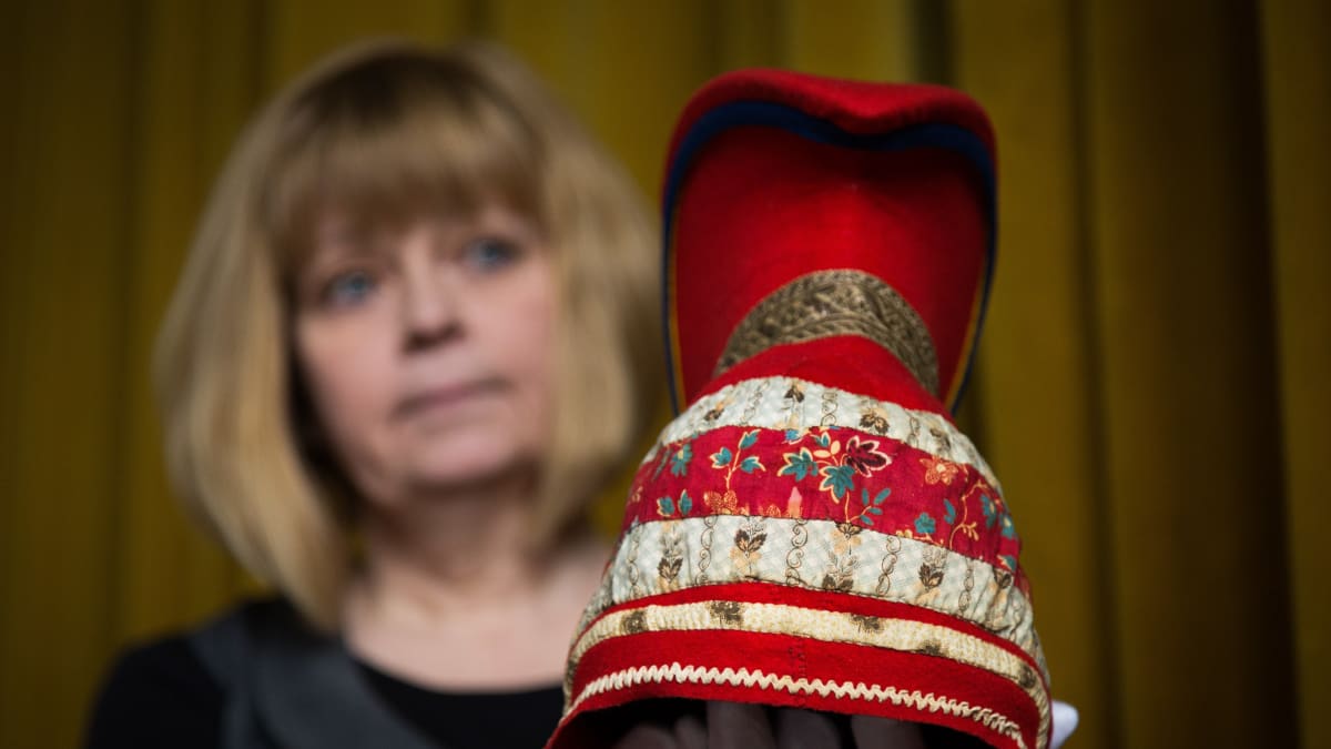 Kansallismuseon intendentti Raila Kataja pitelee kädessään saamelaista sarvilakkia. 