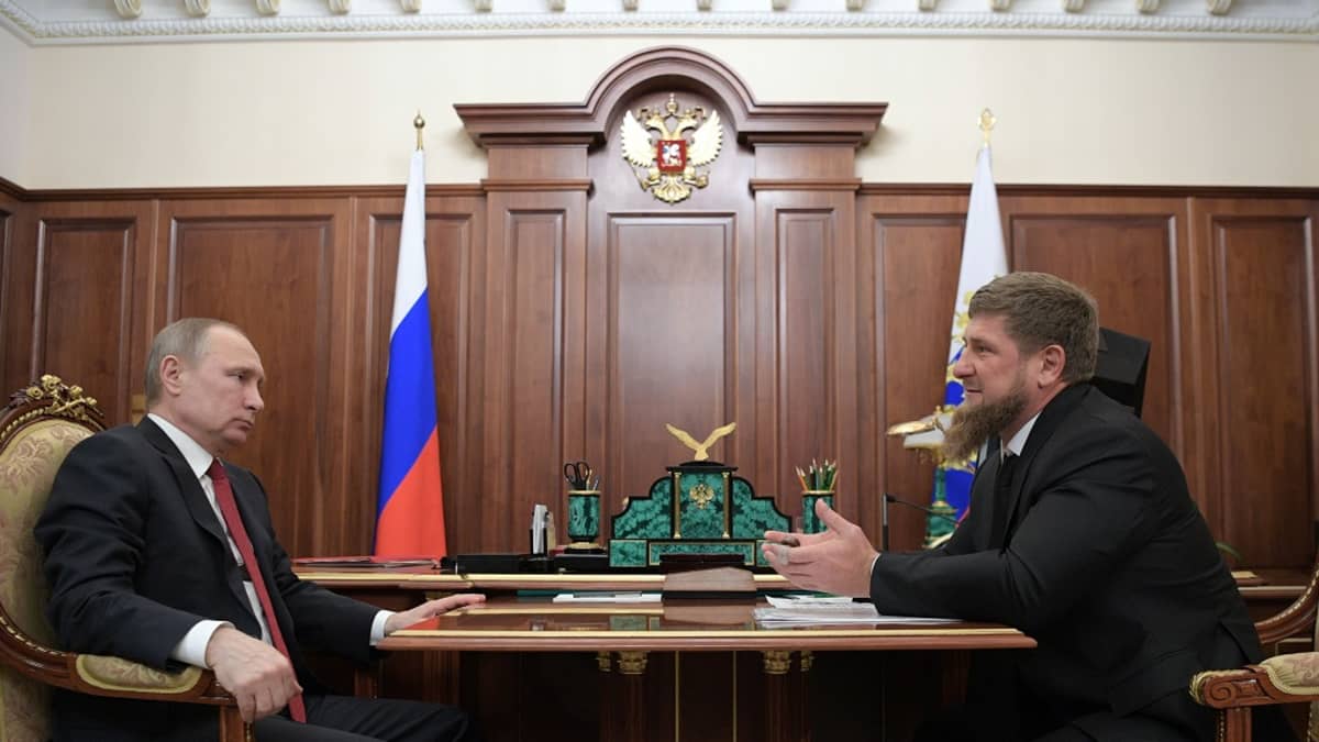 Putin ja Kadyrov istuvat vastakkain presidentin työhuoneessa kirjoituspöydän edessä olevan pienemmän pöydän äärellä. Parrakas Kadyrov selittää juuri jotain käden eteen ojennettuina. Putin kuuntelee vakava ilme kasvoillaan. Taustalla seinän luona on Venäjän lippu ja seinäpaneelissa Venäjän vaakuna, kaksipäinen kotka.