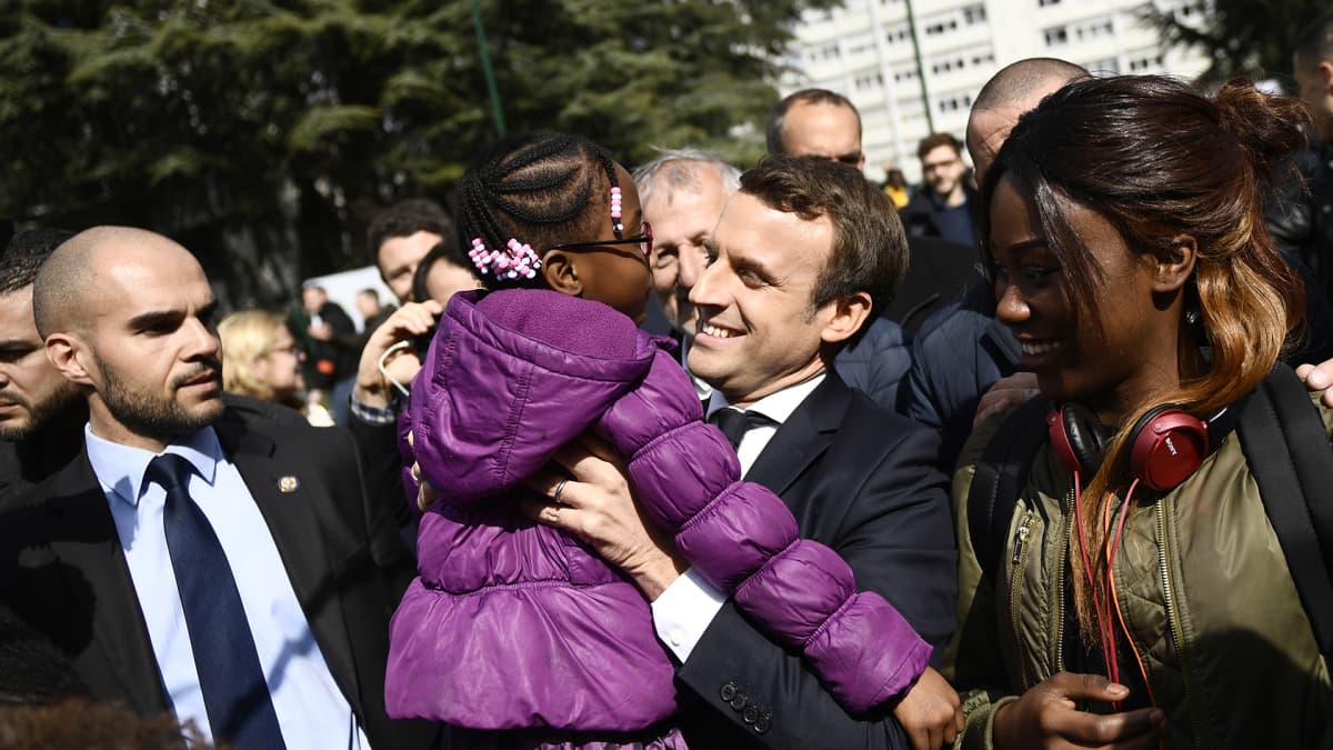 Emmanuel Macron lapsi sylissään kampanjatilaisuudessa