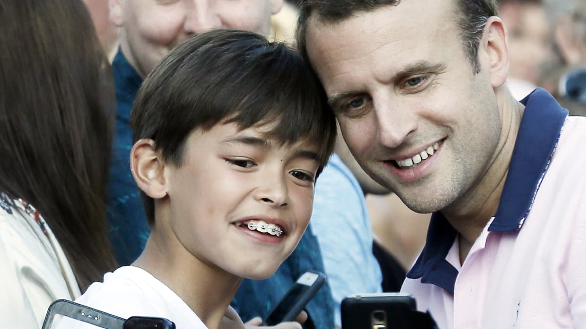 Emmanuel Macron poseeraa lapsen kanssa.
