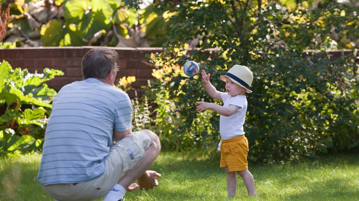 Ukki pelaa palloa lapsenlapsensa kanssa pihalla