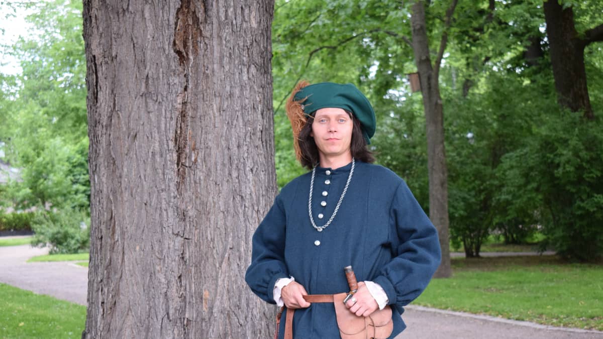 Markkinanäyttelijä keskiaikaisen kirjurin asussa.