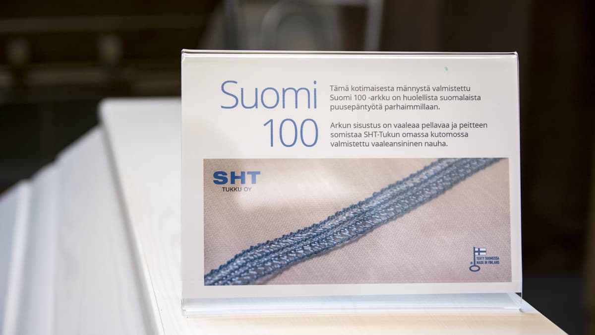 Kyltti Suomi 100 -arkun päällä.