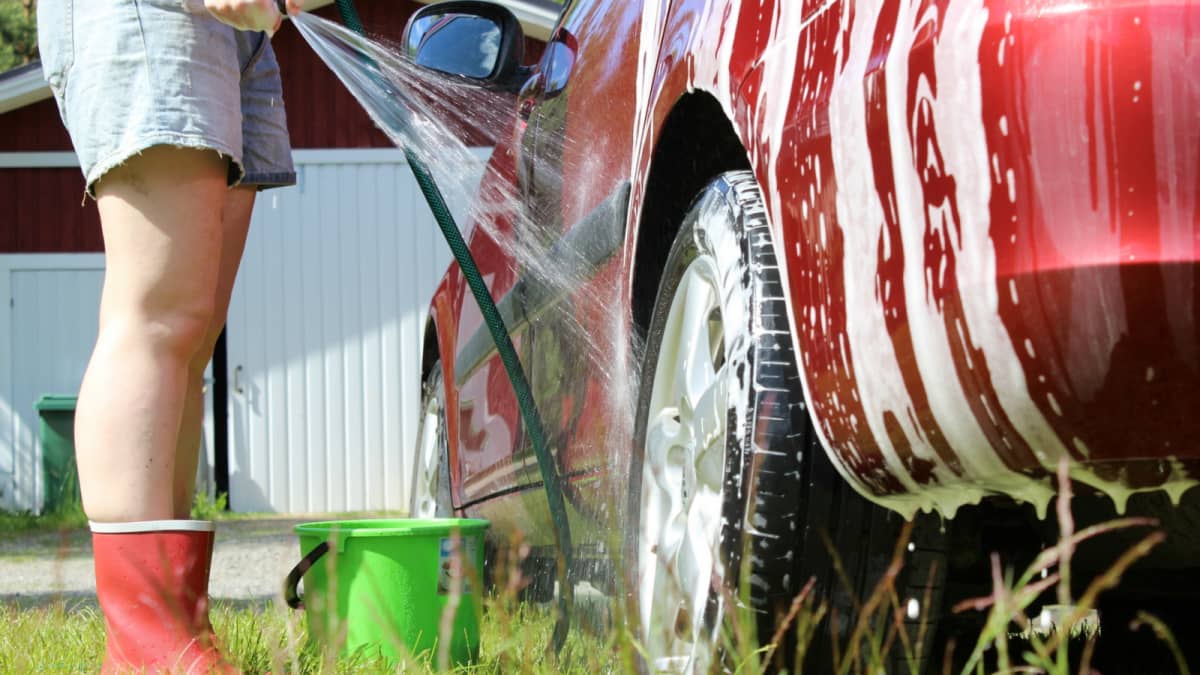 Nainen pesee autoa