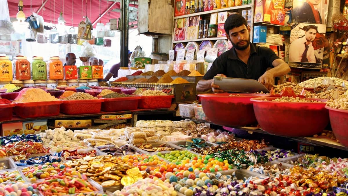 Kuvassa makeisia ja mausteita kaupassa Irakin Bagdadissa. Myyjä annostelemassa myytävää. 