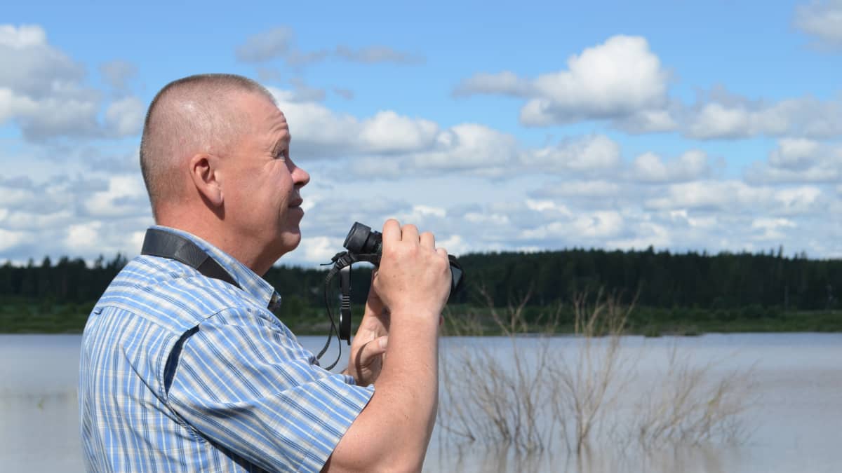 Kouvolan ympäristöjohtaja Hannu Friman kiikaroi lintuja.