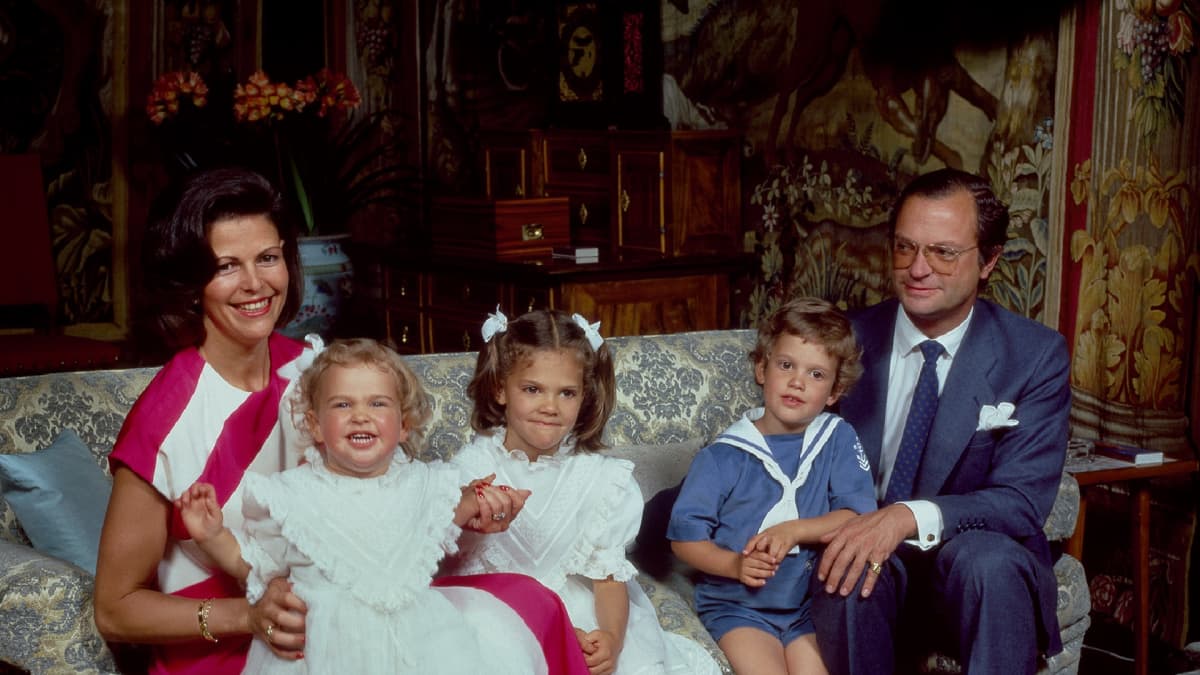 Madeleine istuu kuningatar Sylvia sylissä, vieresssa Victoria (kesk.), Carl Philip ja kuningas Kaarle Kustaa (oilk.)
