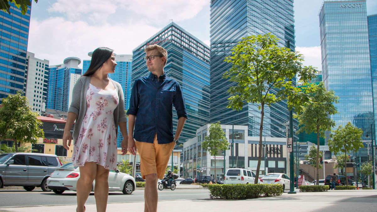 Pariskunta kävelee Manilassa pilvenpiirtäjien lomassa. Juho-Erik Kolehmainen ja hänen tyttöystävänsä Kate luovat molemmat uraa Manilassa. Kesälomia he ovat viettäneet Suomessa, Juhon vanhempien luona Siilinjärvellä. 