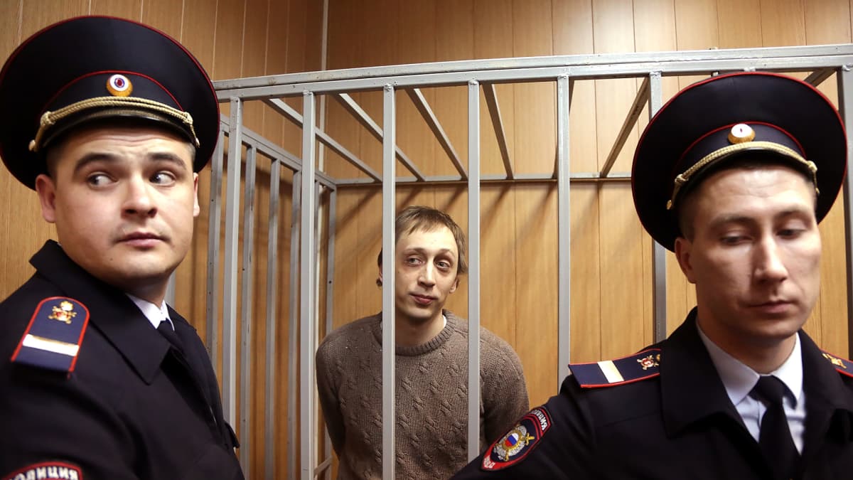Pavel Dmitrichenko häkissä poliisien vartioimana.