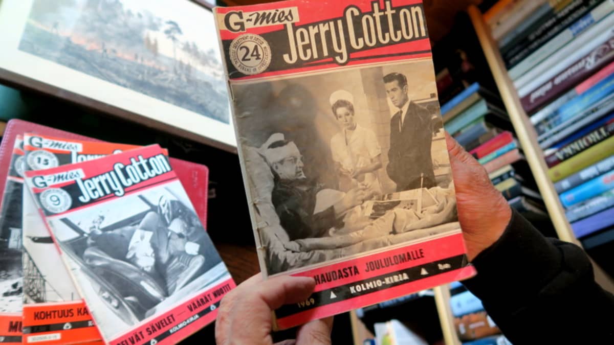 Jerry Cottonin numero 24 miehen käsissä, pöydällä lisää Cotton-lehtiä