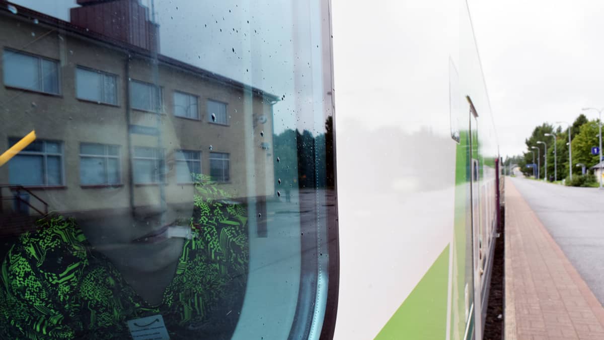 Matkustaja kurkistaa junan ikkunasta rovaniemen asemalla.