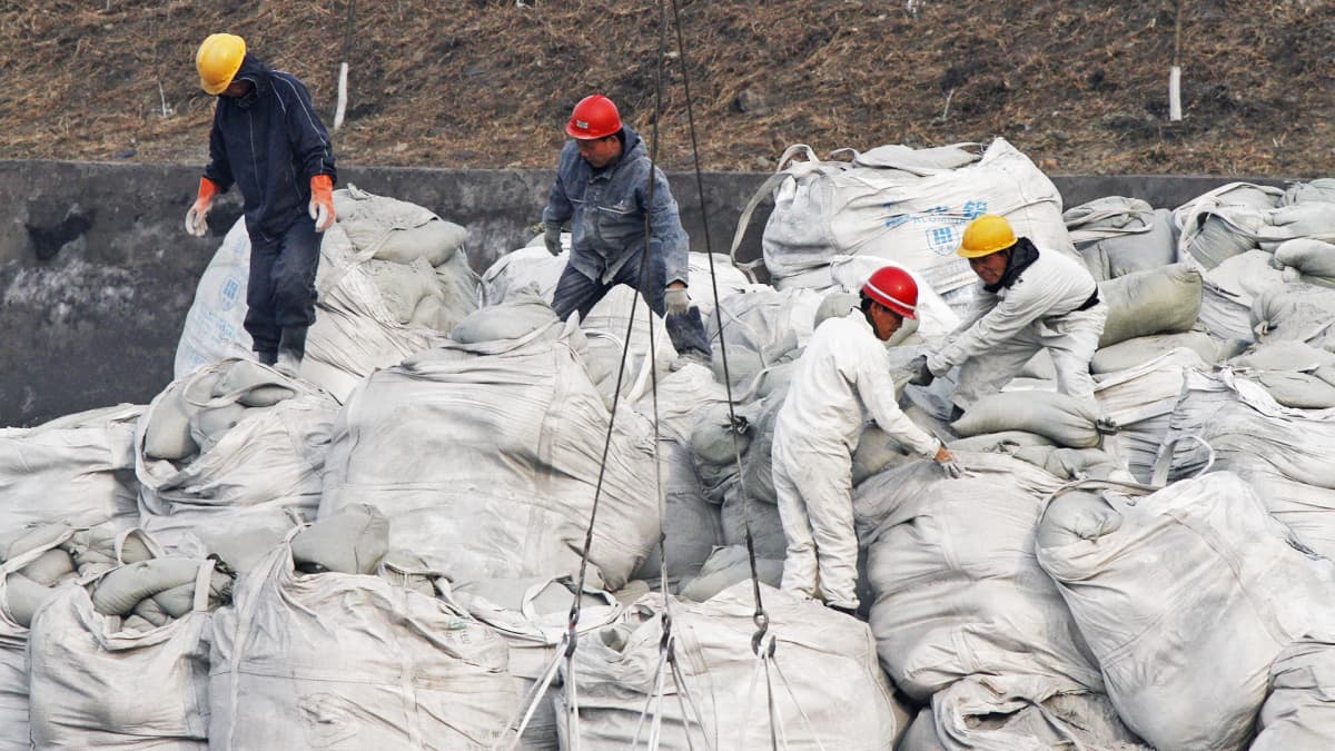 Pohjoiskorealaiset telakkatyöntekijät lastaavat säkkejä.