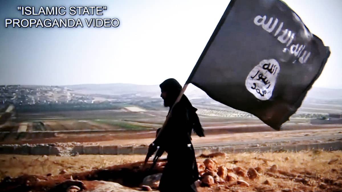 Isis-taistelija ja Isisin lippu. Kuvakaappaus Isisin videosta.