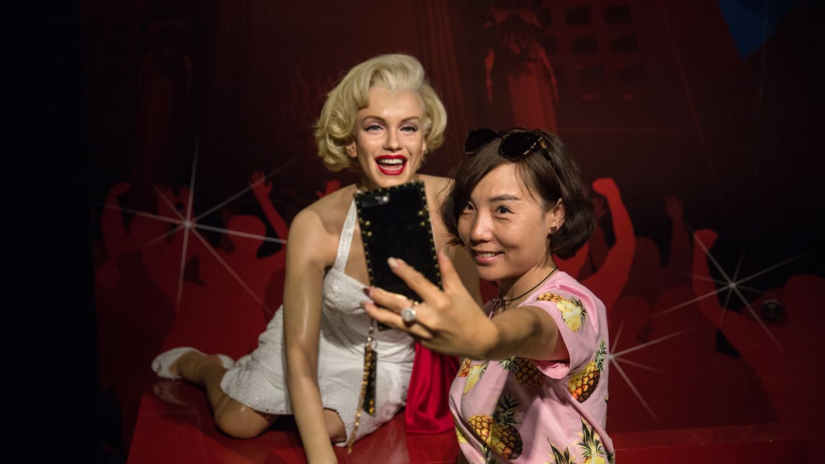 Virailija ottamassa selfietä Marilyn Monroe -nuken kanssa Madame Tussauds -vahakabinetissa Pekingissä, Kiinassa 11. elokuuta.