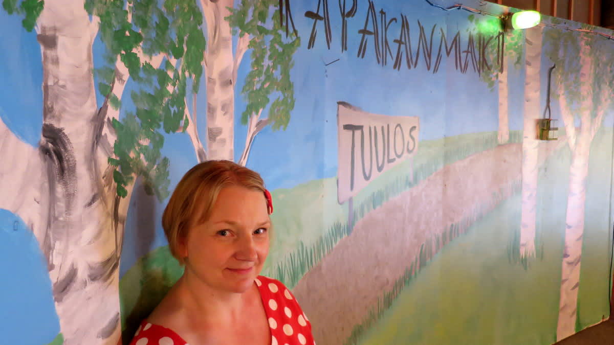 Nuori nainen seisoon seinämaalauksen edessä jossa lukee Kapakanmäki
