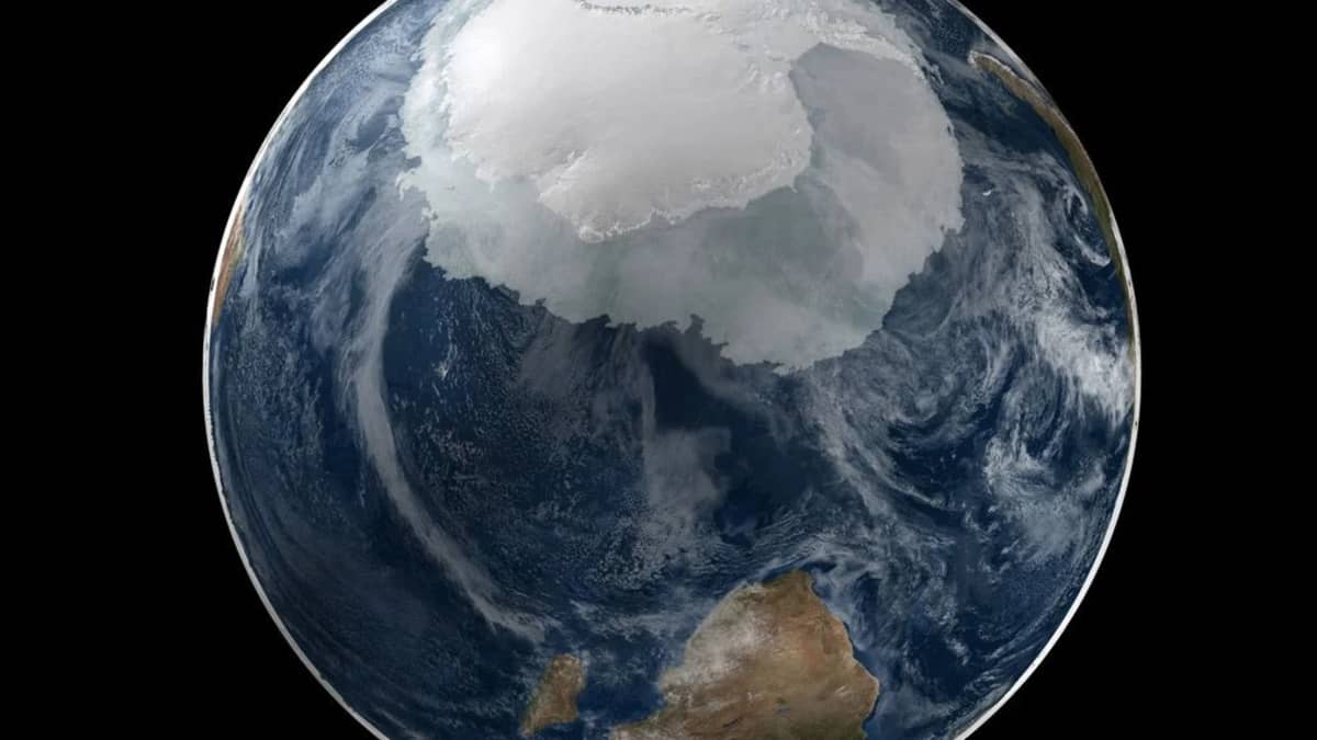 Etelämantereen rosoreunainen pyörylä keskellä sinistä merta, jonka yllä on pilviä. 