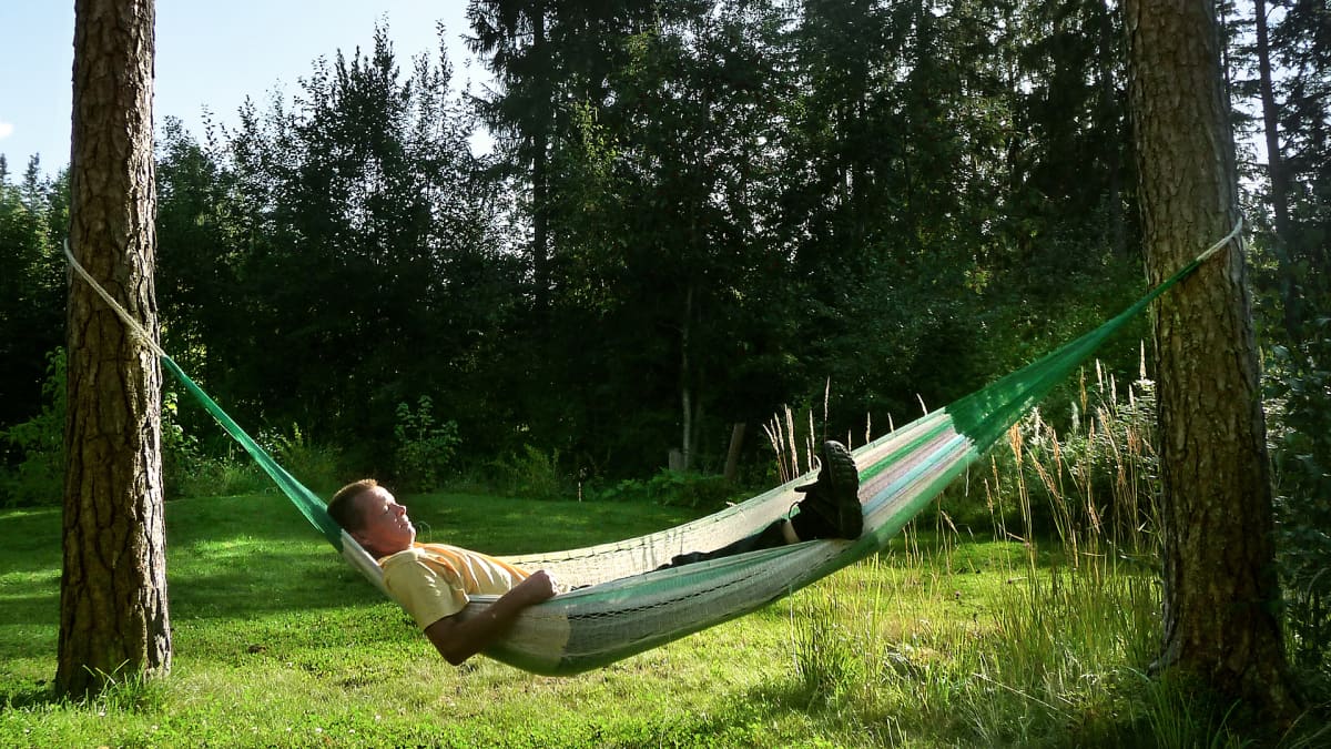 Mies makaa riippumatossa.