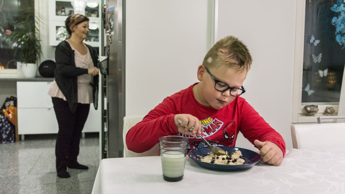 Otso Soini syö aamupuuroa keittiön pöydän ääressä.