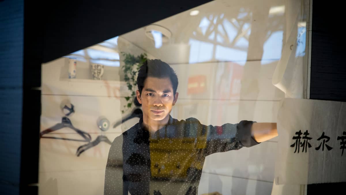 Ryan Zhu katsoo mökin ikkunan läpi 