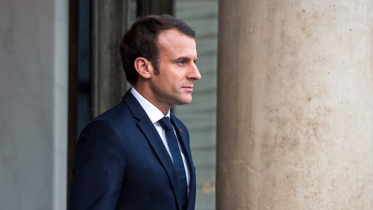 Ranskan presidentti Emmanuel Macron seisoo pylvään vierellä.