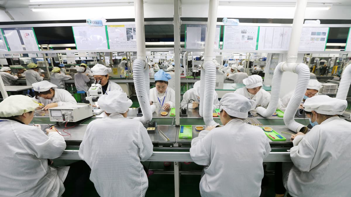 Työntekijöitä kokoamassa puhelimia Huaibein tehtaalla Anhuin maakunnassa.