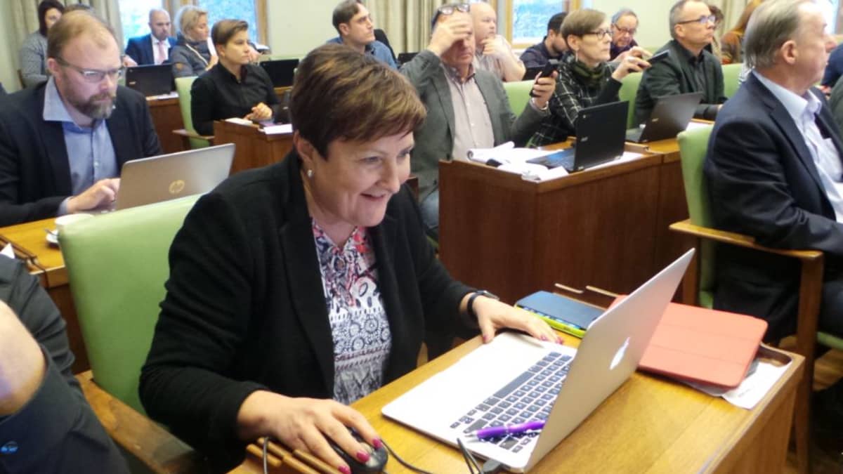 Porin kaupunginjohtaja Aino-Maija Luukkonen Porin valtuustossa 13.11.2017, katsoo tietokonetta, on iloinen.