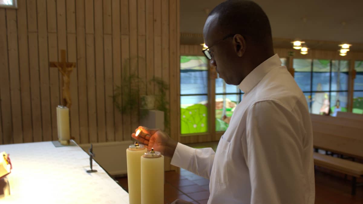 Jean Claude Kabeza sytyttää kynttilää