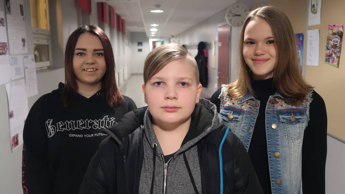 Hämeenkyrön yhteiskoulun yläkoululaiset Hanne Mäki ja Eemeli Jokinen sekä lukiolainen Maija Veteläsuo koulun käytävällä.